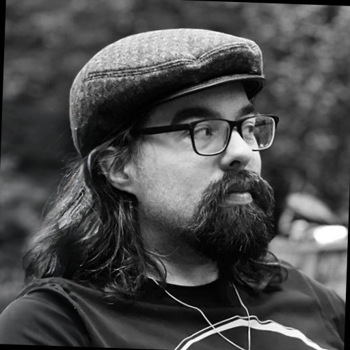 a bearded man with hat and glasses